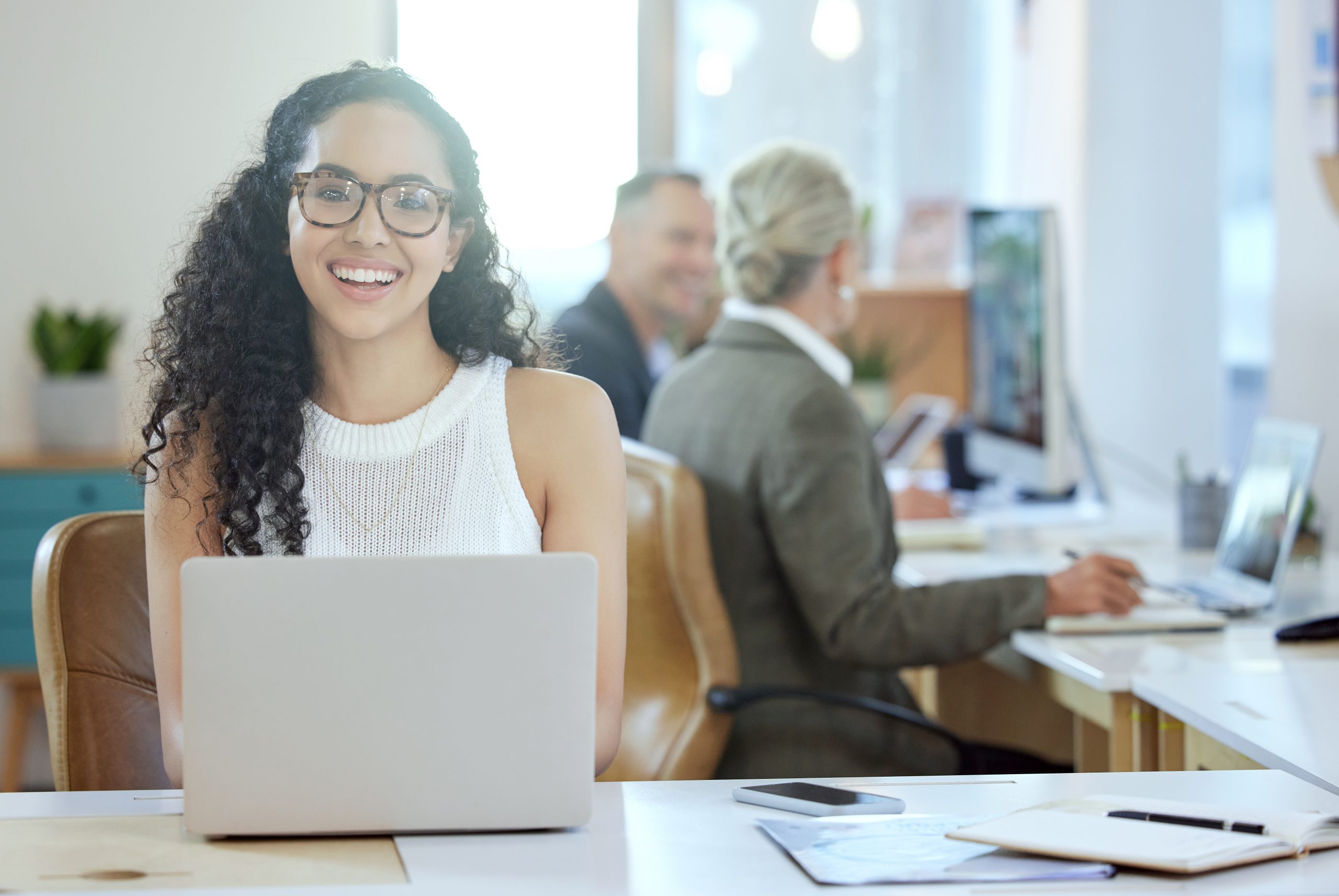 Shot of a young businesswoman using a laptop in an office at work.